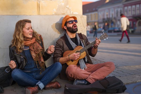 Young people playing music and singing together on the street